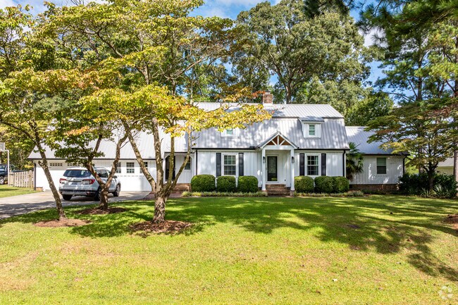 A Dutch Colonial home in Brice’s Creek is shaded by mature trees.