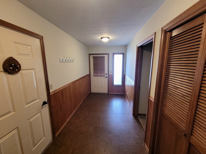 Front door, entry-way, left door to garage, right door to bedroom, right coat closet