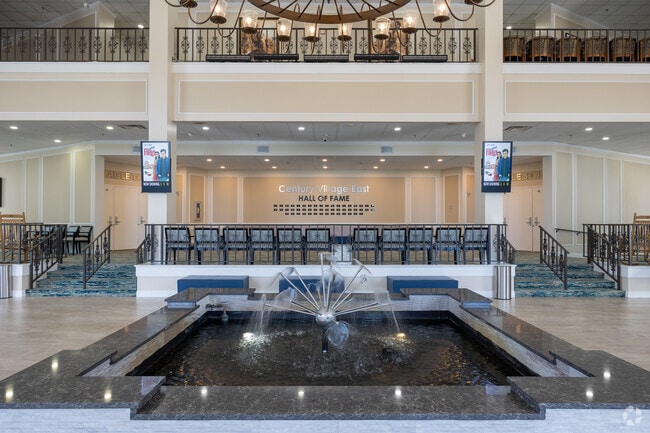 Century Village Club house lobby has an indoor water fountain and a wall of fame display.