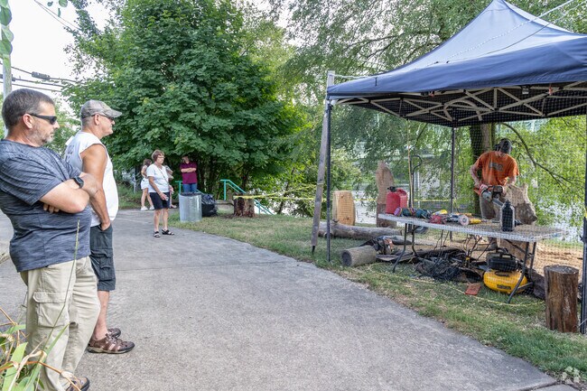 Residents enjoy watching wood carving at the Fort Armstrong Folk Festival.