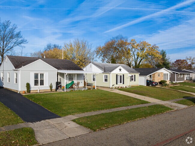 A row of minimal traditional-style homes with large yards in Mayflower Village.