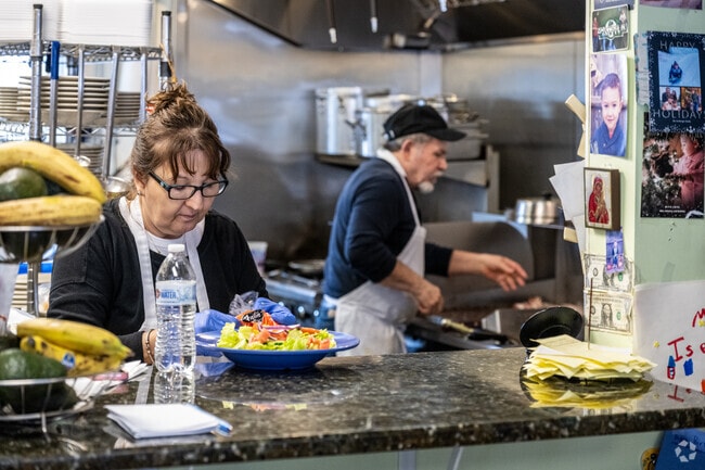 Workers prepare lunch at Theo's Breakfast & Lunch Restaurant in Paxton.
