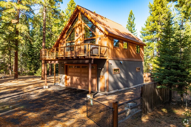 A-frame cabin-style home offers rustic charm amid towering pines.
