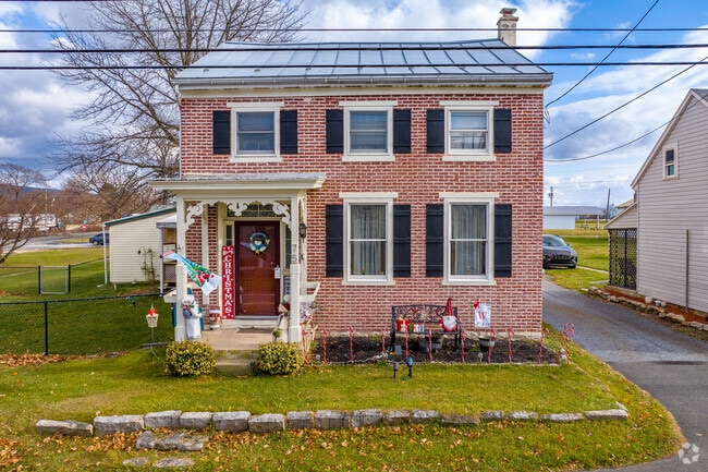 Brick colonials borrow Queen Anne architectural features with designs on the front porch.