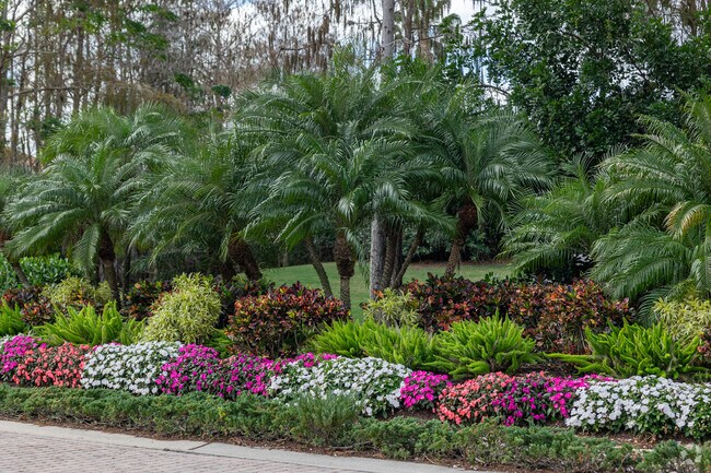The landscaping around the Olde Cypress community is lush and adorned with colorful flowers.