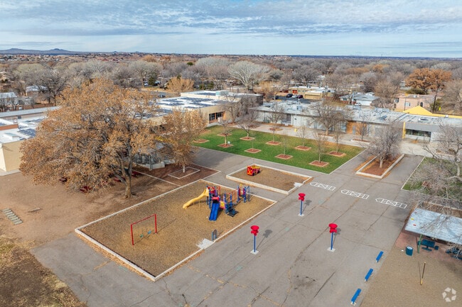 Playground equipment and Reginald Chavez Elementary's main building.
