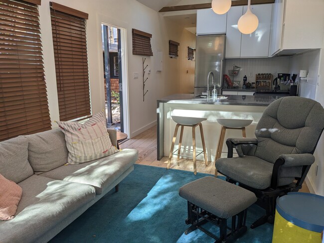 Living room is furnished with a couch, chair and ottoman, and two side tables.