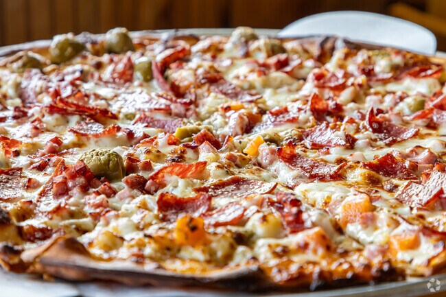 The muffuletta pizza is a local favorite at the Olive Branch Club in Tall Timbers.