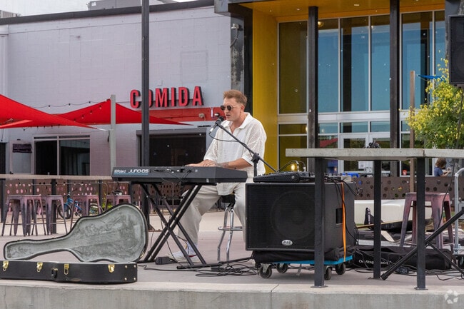 A musician performs outside Stanley Marketplace, a North Aurora community hub.