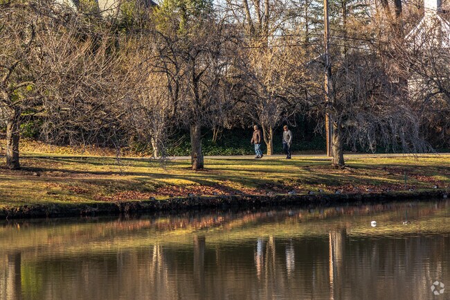 A resident enjoys a walk by the trees around Third Ward Memorial Park's central lake.