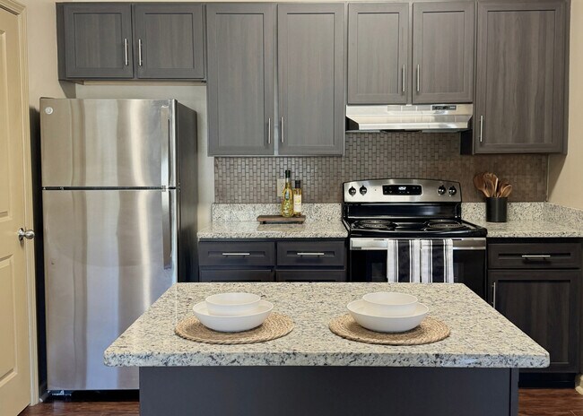 Large Kitchen Island with Espresso Cabinets, Granite Countertops, and Stainless Steel Appliances