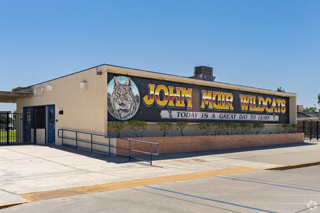 A large colorful mural at the entrance to John Muir Middle School features the school mascot.