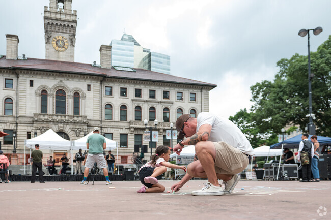 Parent and child draw with chalk on the Worcester Common floor at Out to Lunch Festival near Crownhill-Piedmont.