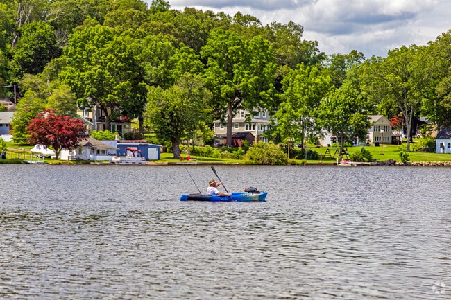 Netcong Lake invites peaceful moments of solitude and connection with nature as residents paddle past charming waterfront homes surrounded by lush greenery.
