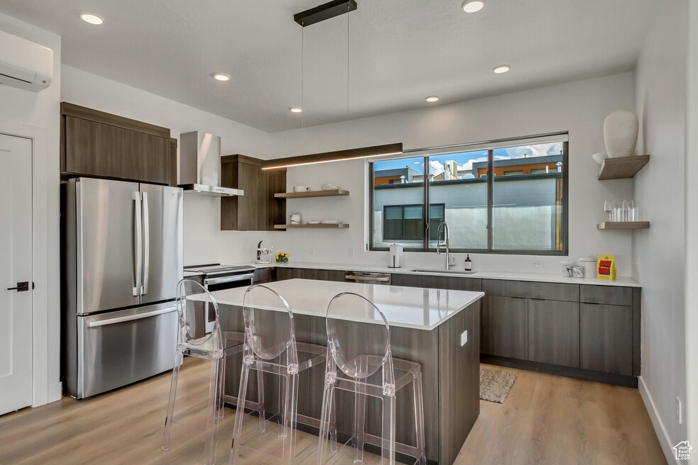 Kitchen with appliances with stainless steel finishes, open shelves, wall chimney exhaust hood, mode