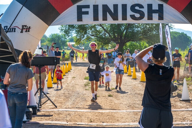 A runner excitedly crosses the finish line at the Chips and Salsa Half Marathon, just a short drive away from Ventana Ranch.