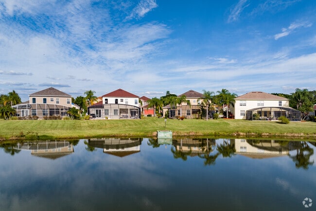 A beautiful row of two story waterfront homes in The Oaks Golf & Community in Lake Toho.