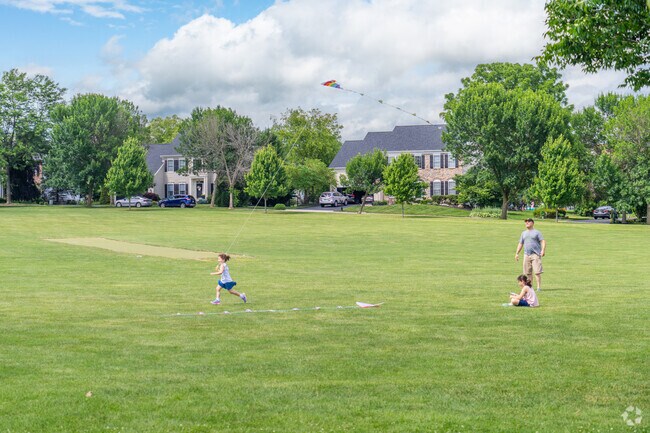 Kids fly kites in the open green space at Farmington Hills Park.