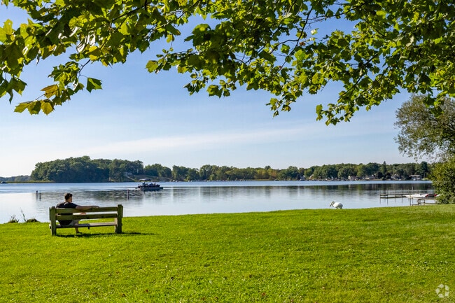 A waterside bench lets locals soak in the view as boats go by at Little Wolf Lake County Park.