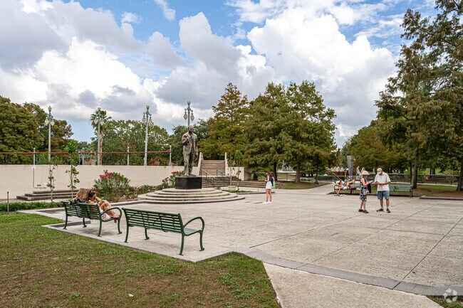Visitors to Louis Armstrong Park take in the sculpture of the park’s namesake, Louis Armstrong.