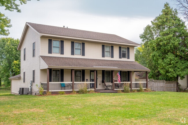 A spacious white home with a welcoming porch and yard showcases Mayer’s traditional single-family housing style.