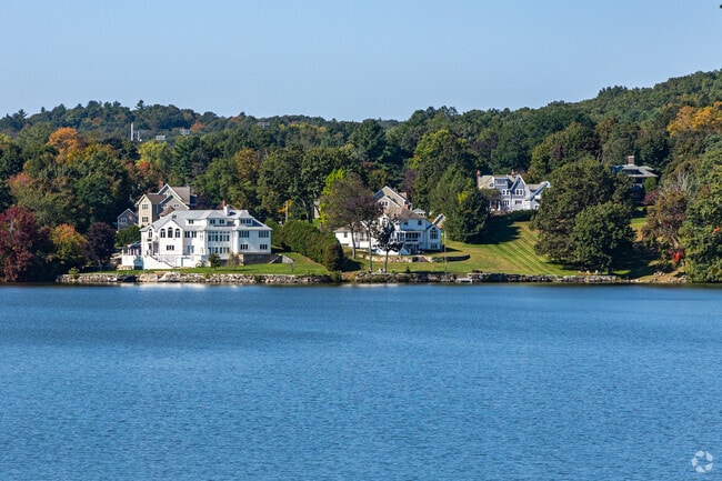 A group of large home sit along the shores of the Indian Lake shores.