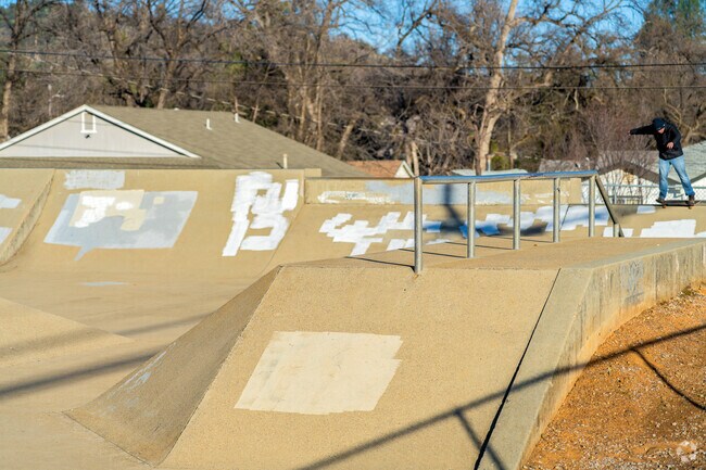 A man does a 50-50 stall on the Claire Engle Park skate park coping.