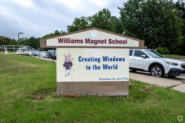There is a sign for Williams Science & Fine Arts Magnet School near the road.