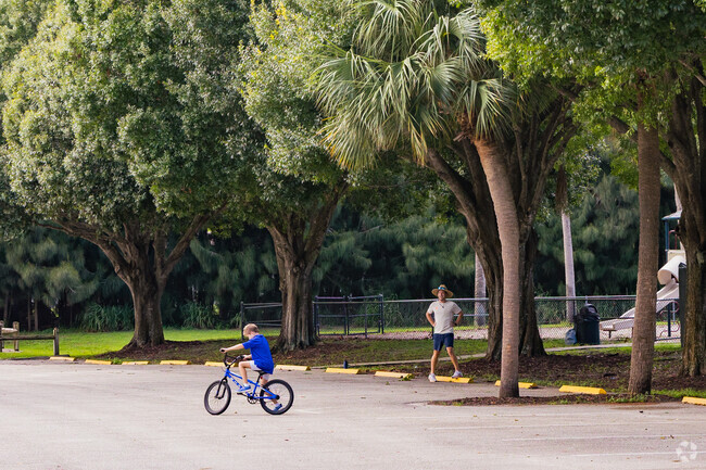 A father teaches his son bike tricks in Maplewood Park.
