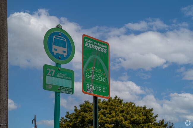 Bus stop in residential area offering a free local bus, the Miami Gardens Express or a Miami-Dade Public bus.