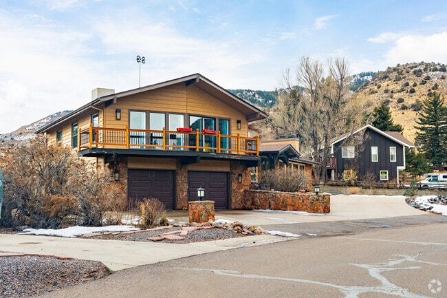 Log-style A-frame mountain homes sit on curved streets in Morrison.