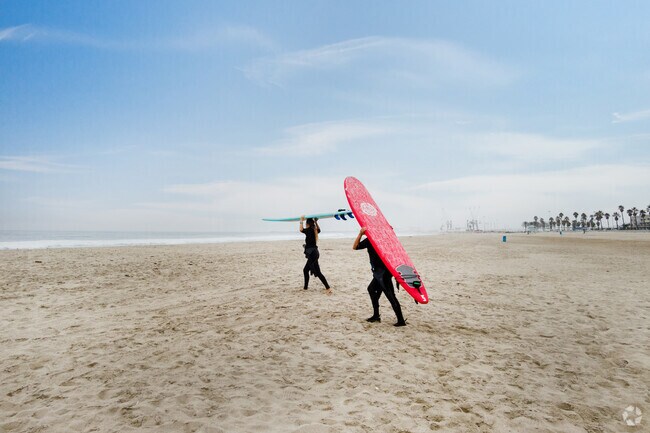 2 surfers going to water 2