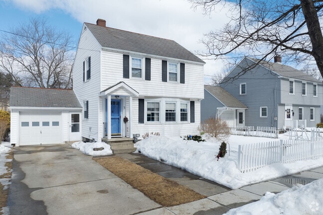 Two Colonials sit nicely by each other enjoying the snow and waiting for the spring flowers to bloom.