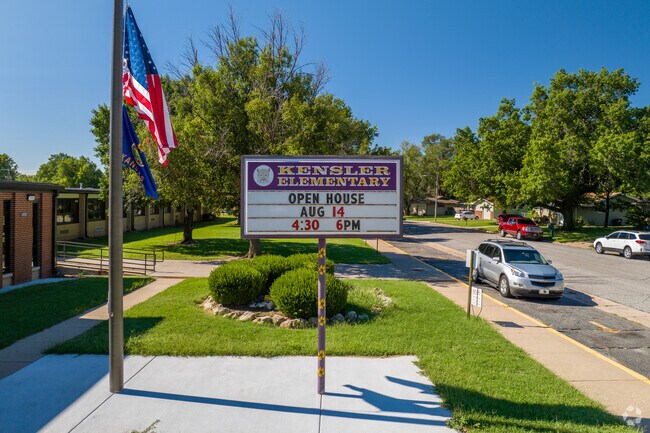There is a sign for Kensler Elementary School near the street.