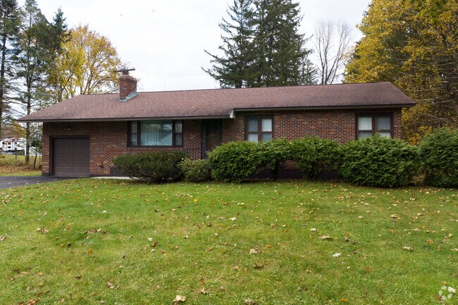 This brick ranch home in Charlton sits behind a hedgerow.