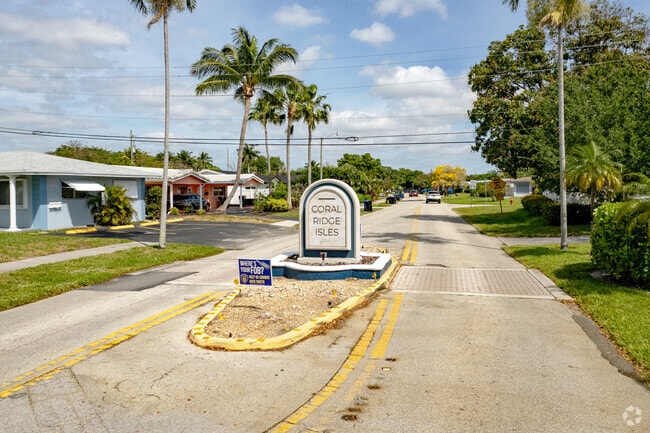 Palm trees line the entrance to Coral Ridge Isles, adding to its tropical charm.