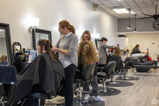 Hairdressers at Luxe on Main in Chatham, NJ, trimming and chit-chatting with happy customers.