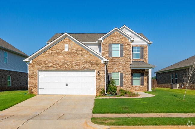 New build craftsman homes in West Huntsville have lush grass and are made of brick.