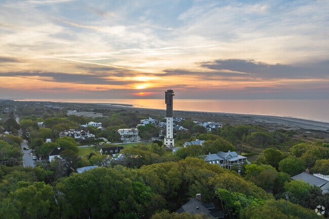 Above the homes and tree lines in Sullivan's Island is the Charleston, SC lighthouse.