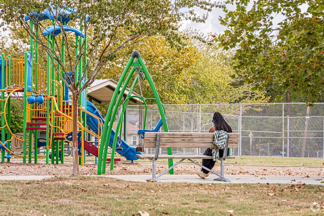 Families can relax on benches by the playground at Mills Avenue Park in Highland Farms.
