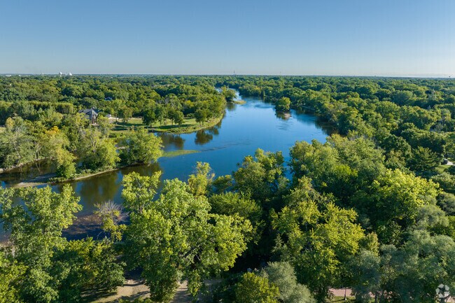 Beautiful aerial view of the Fox River surrounded by mature tall trees in Oswego, IL.