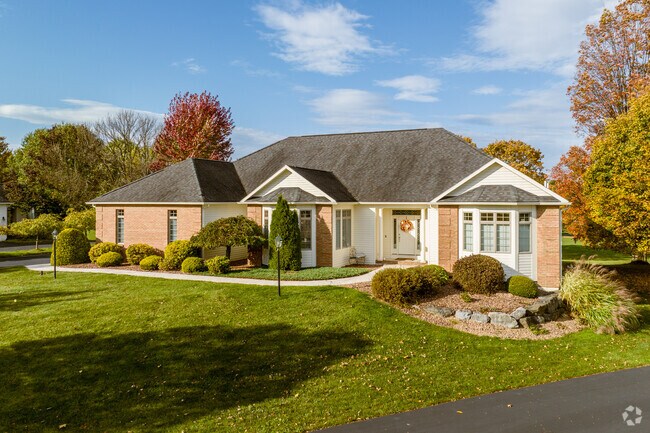 Hipped, cross-gabled brick ranches grace the perimeter of a golf course in Jamesville.
