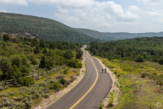 A pair of friends bike up the road that runs alongside the Timber Lakes neighborhood.