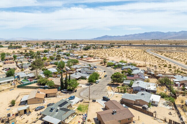 Yards in Yermo are mostly desert, bordered by iron fences and dotted by hardy bushes.
