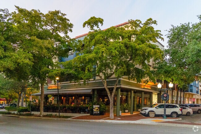 Brick sidewalks, tree-lined paths, and stucco storefronts create a picturesque downtown atmosphere in Miami Lakes.