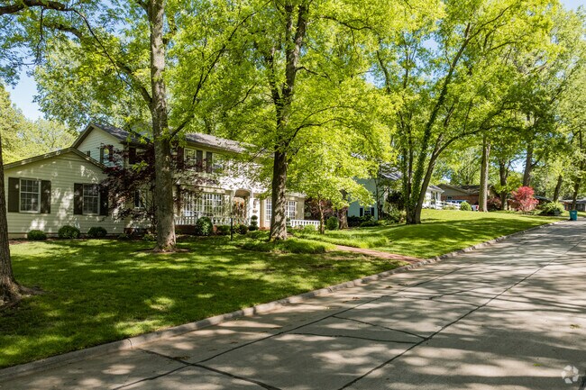 Homes of different shapes and sizes are shaded by large trees in Brentwood.