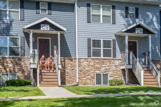 Two students sit on their townhouse stoop in Knollwood.