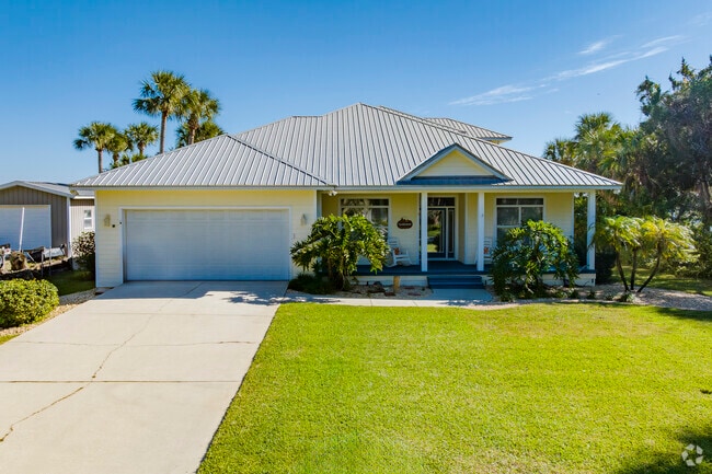 This single family Harbor Oaks home boasts a well manicured lawn and ample trees.