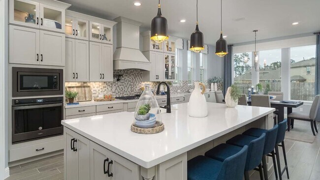 Elegant cabinetry and quartz island enhance this kitchen's luxurious ambiance in Mostyn Manor Reserve.