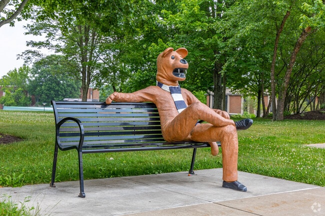 Penn State Beaver mascot greets visitors near campus seating.